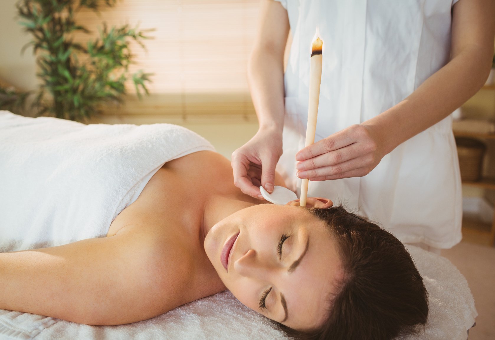 Young woman getting an ear candling treatment